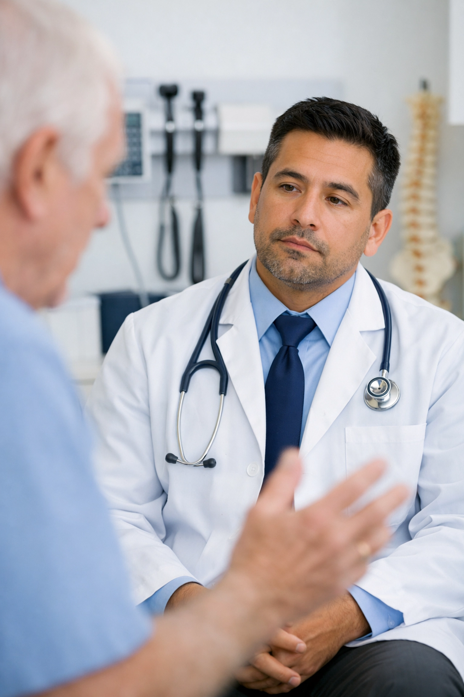 Clinician in a patient exam room showing signs of detachment due to automated AI scribe documentation processes.