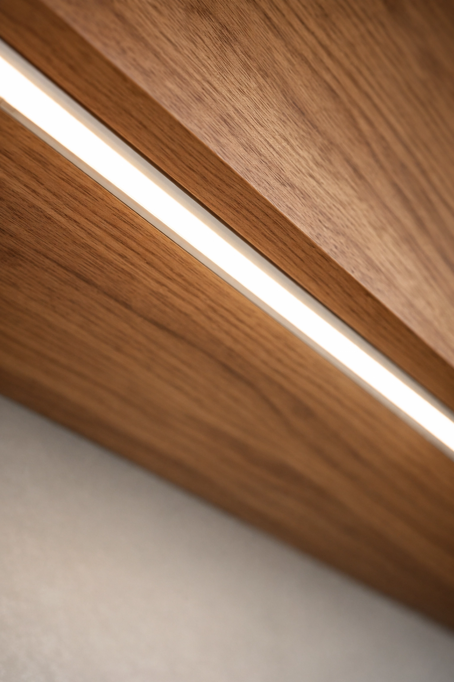 Installation soignée d'un éclairage sous les armoires avec profilé LED encastré et câblage invisible.