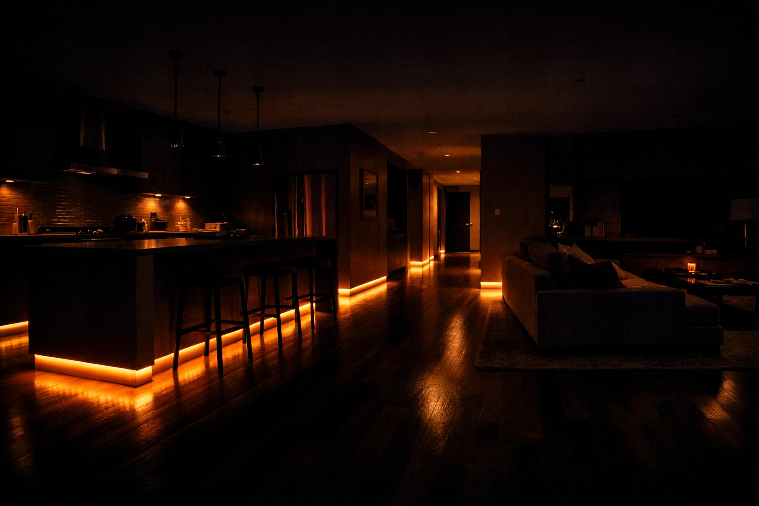 Soft amber LED strip lights for kitchen toe-kicks illuminating a hardwood floor at night.