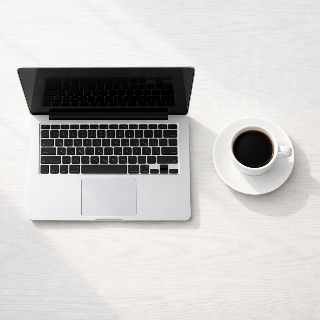 Minimalist workspace with a laptop and coffee for a miami event photographer editing photos.