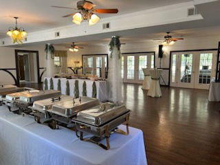 Bright indoor reception space at The Sugarhouse with hardwood floors, large windows, and a buffet setup ready for guests.