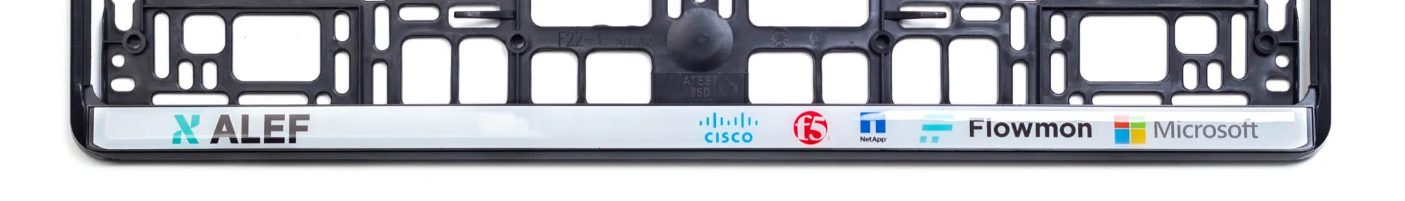 Egyedi gyártású, műanyag rendszámtábla tartó keret, alsó csíkon több céges logóval ellátva