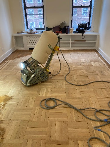 Professional Floor Sander in Use for Dustless Parquet Refinishing