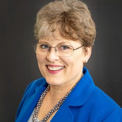 Smiling woman in blue blazer representing ERISA guardians and compliance support.