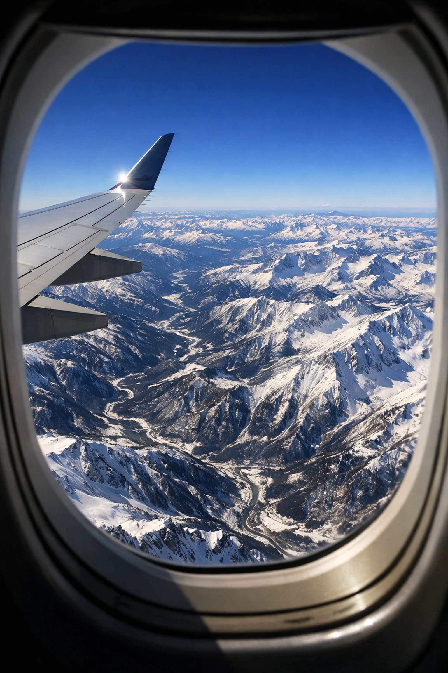 Aerial view of the Rocky Mountains from an airplane, highlighting the scale of Mountain Time zone transitions.
