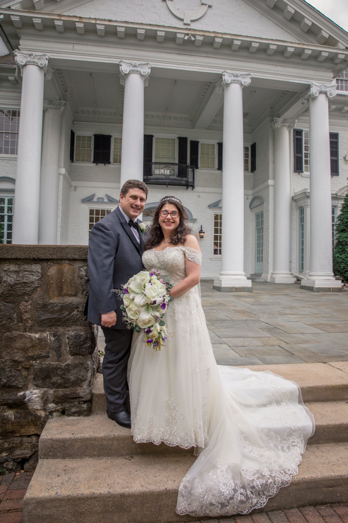Bride and groom standing together indoors, smiling in warm light