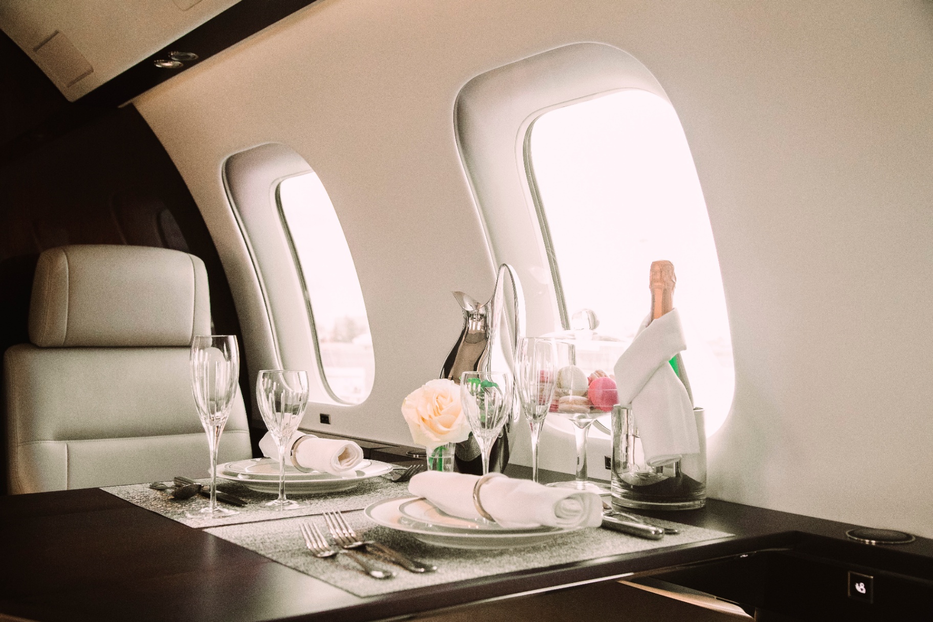 Private jet cabin table setting with champagne and fine dining
