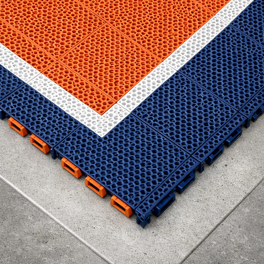 Close-up of interlocking blue and orange modular tiles for a professional pickleball court.