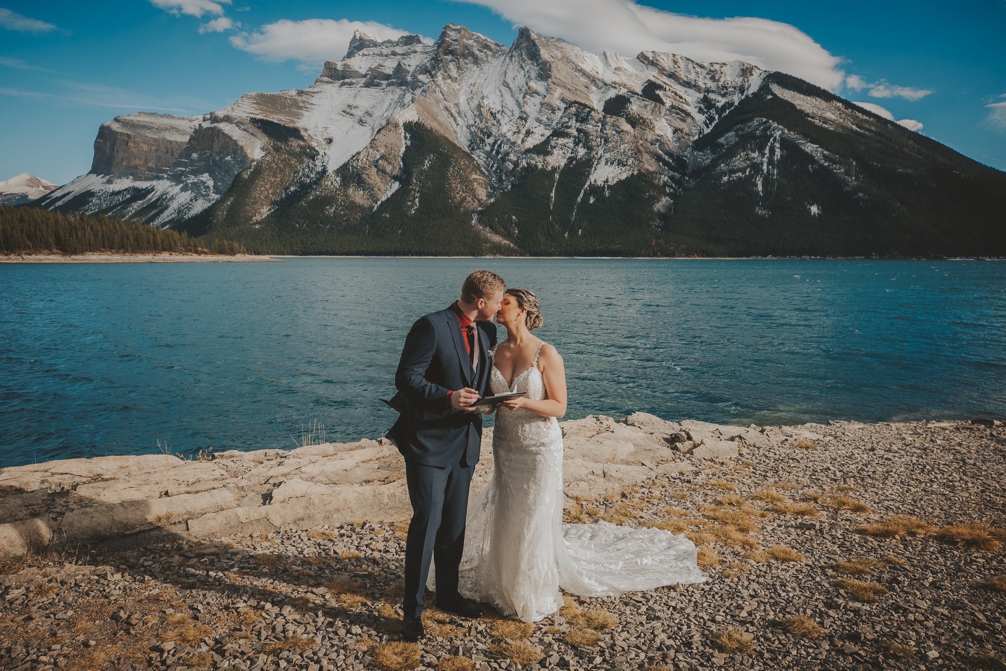 A couple shares a kiss during their elopement ceremony at Lake Minnewanka