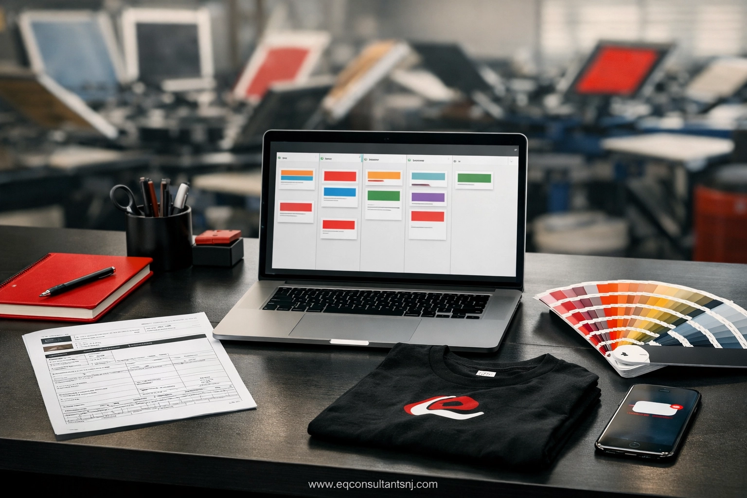 A modern screen printing shop office desk using workflow automation software for production management.