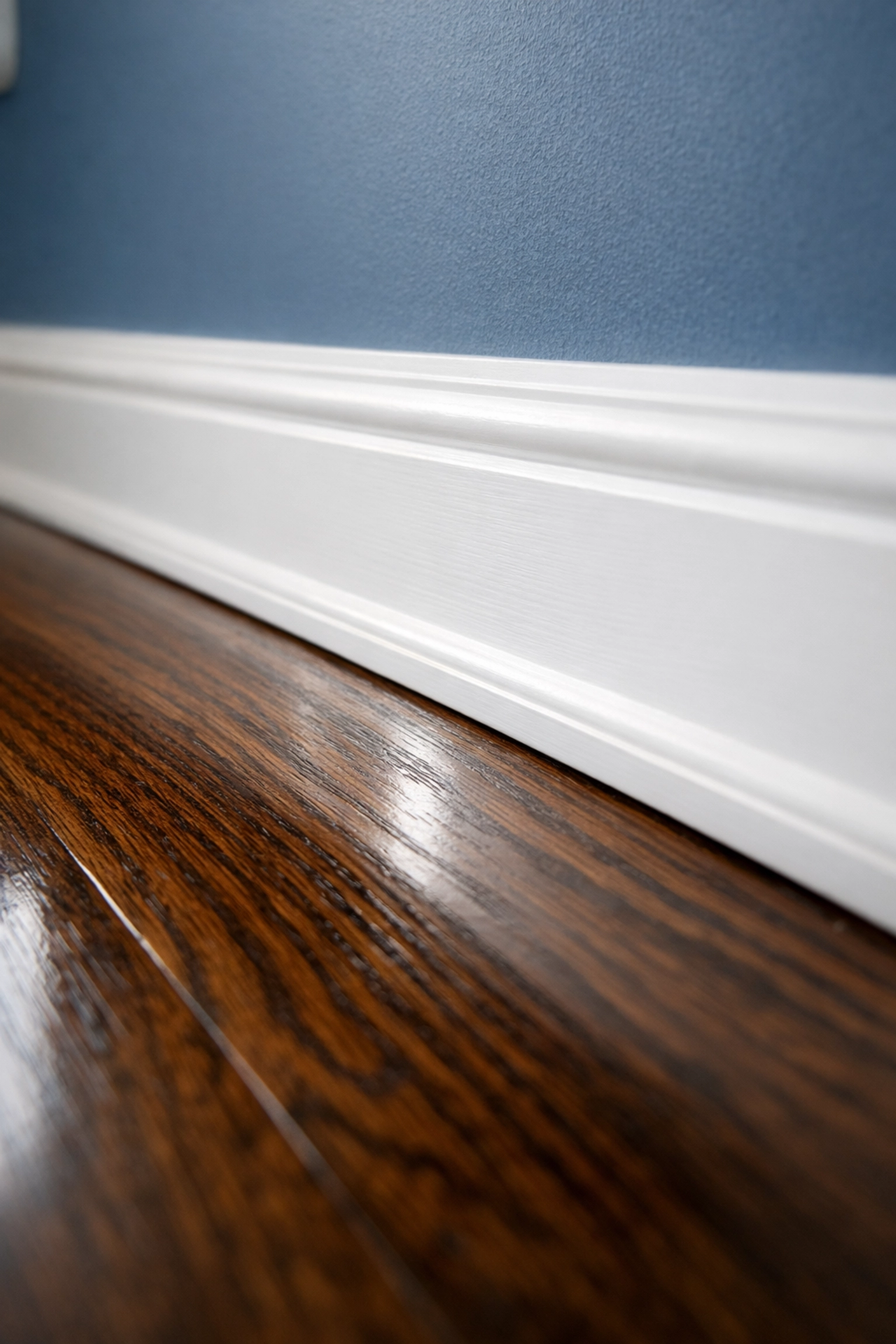 Detailed professional cleaning of baseboards and polished hardwood floors in a Cambridge home.
