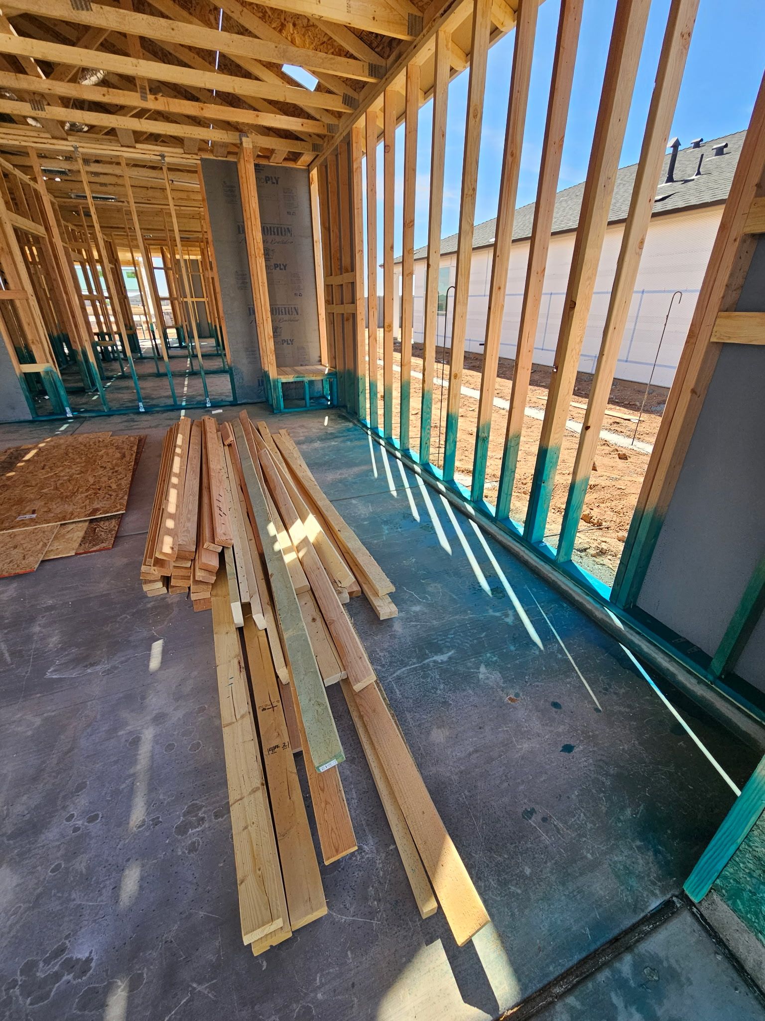 Framing stage of a new Arizona home with exposed lumber and visible gaps around exterior walls.