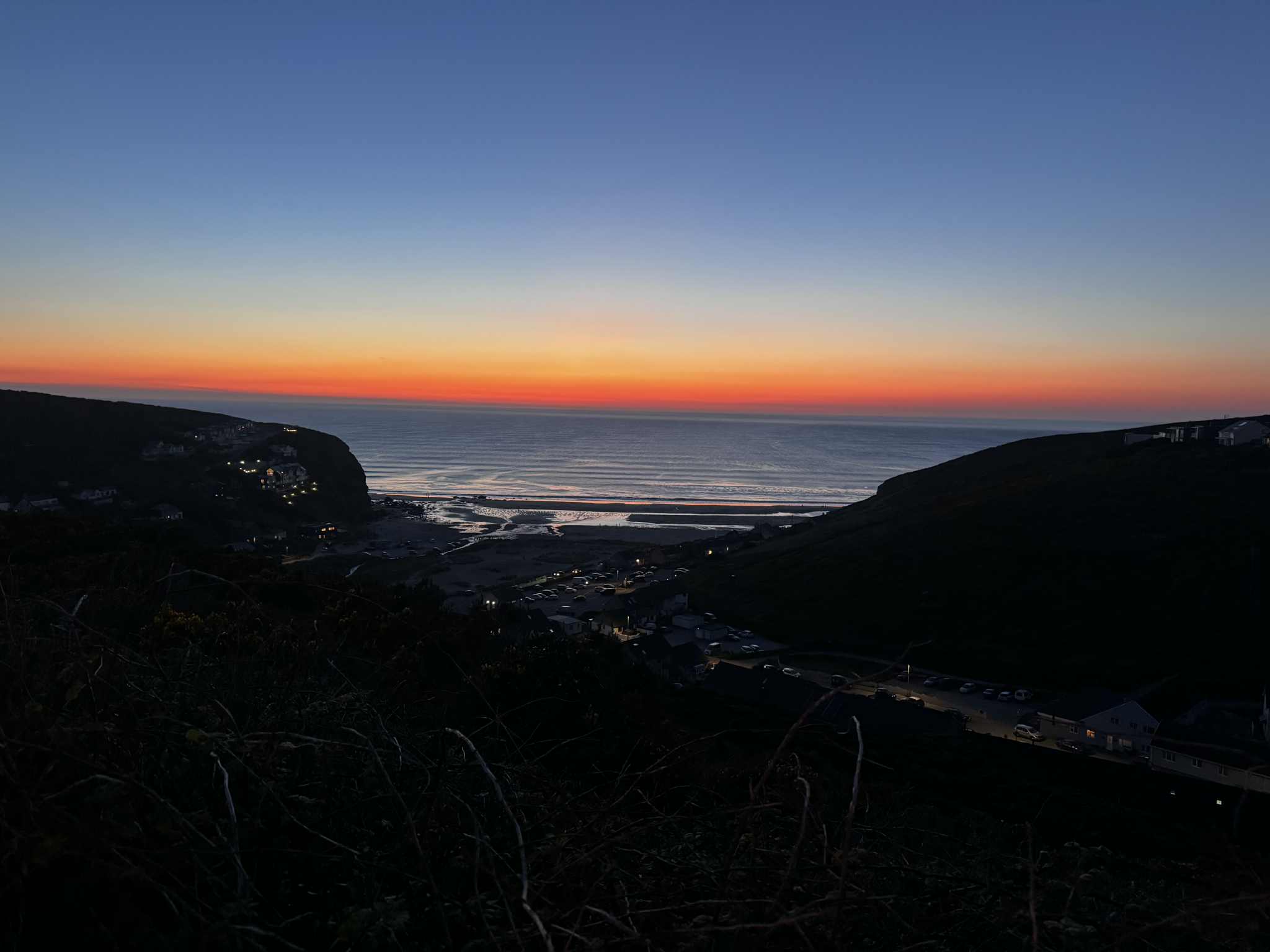 Sunset view over Porthtowan Beach with the sea and headlands visible