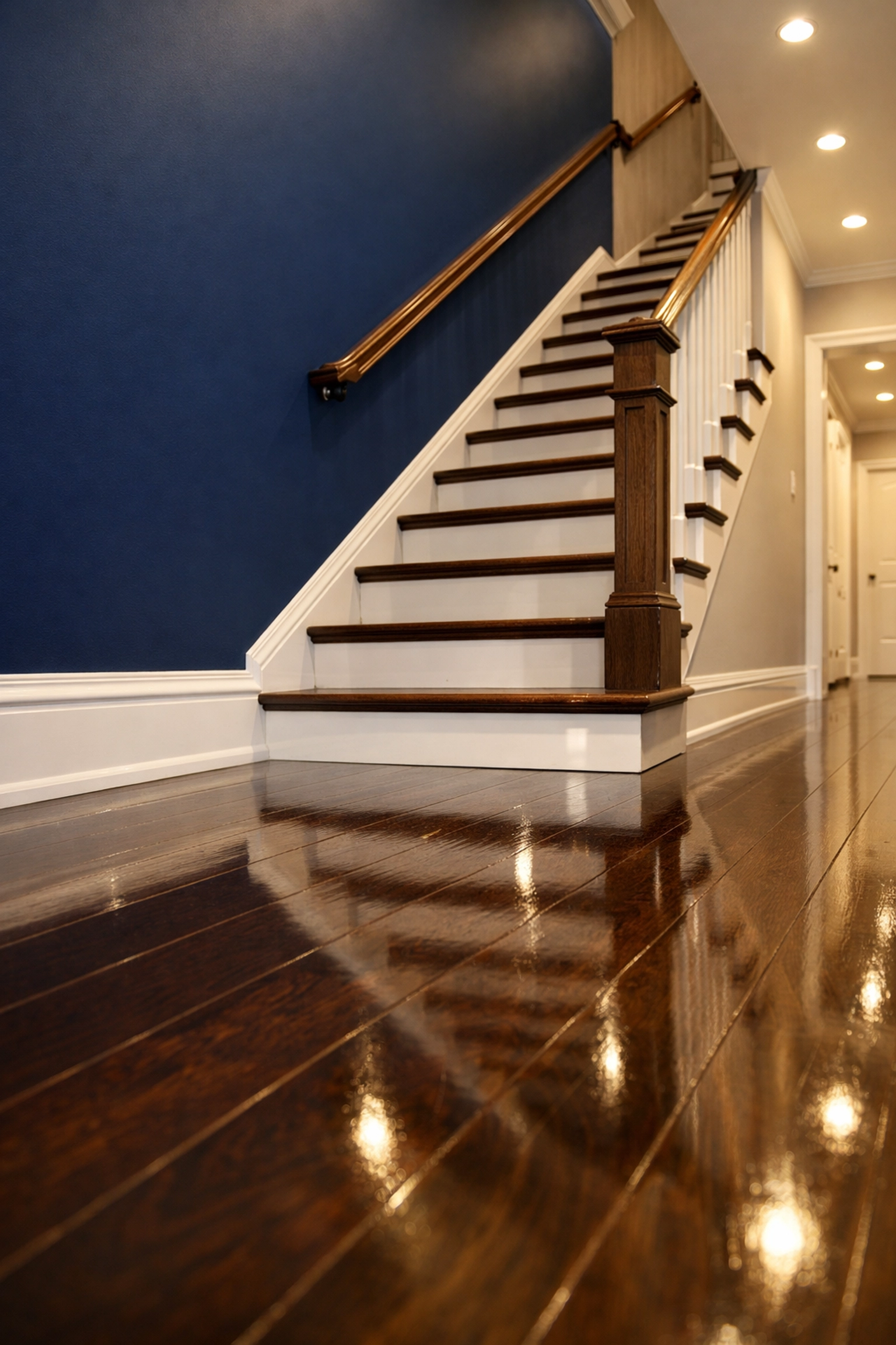 Spotless dark wood stairs and white baseboards in a Maynard home after professional post-construction cleaning.