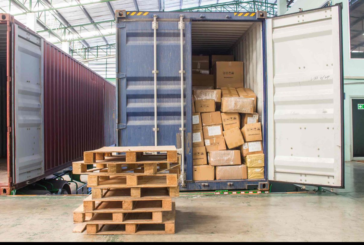 A shipping container loaded with sealed cardboard boxes, ready for export in an organized warehouse.