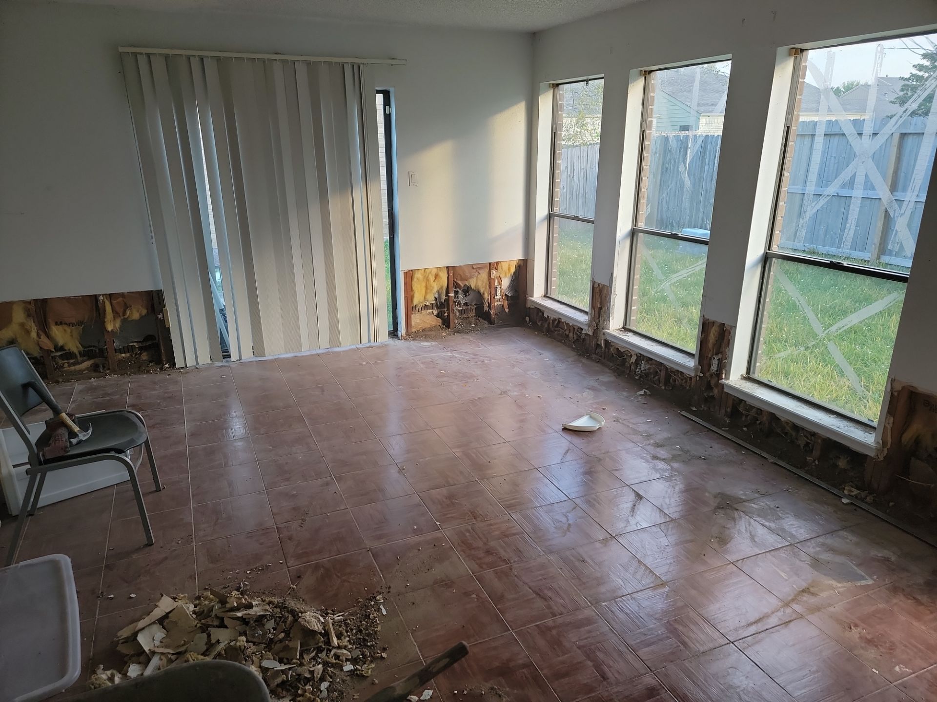 A living room with lower drywall removed around the perimeter due to water damage