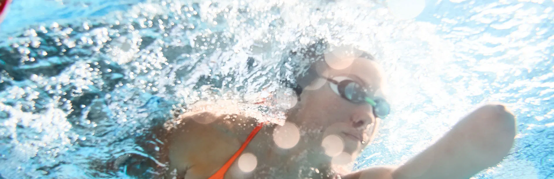 An underwater shot of a swimmer showing focus and determination, representing the breakthrough of physical and emotional obstacles.