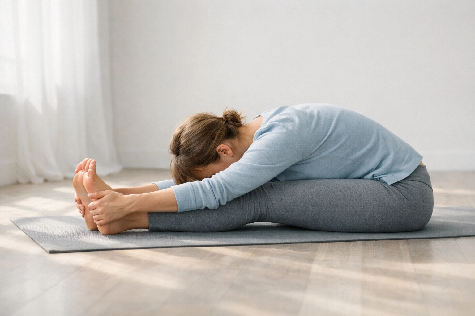 Person performing gentle yoga stretches demonstrating active recovery for muscle healing