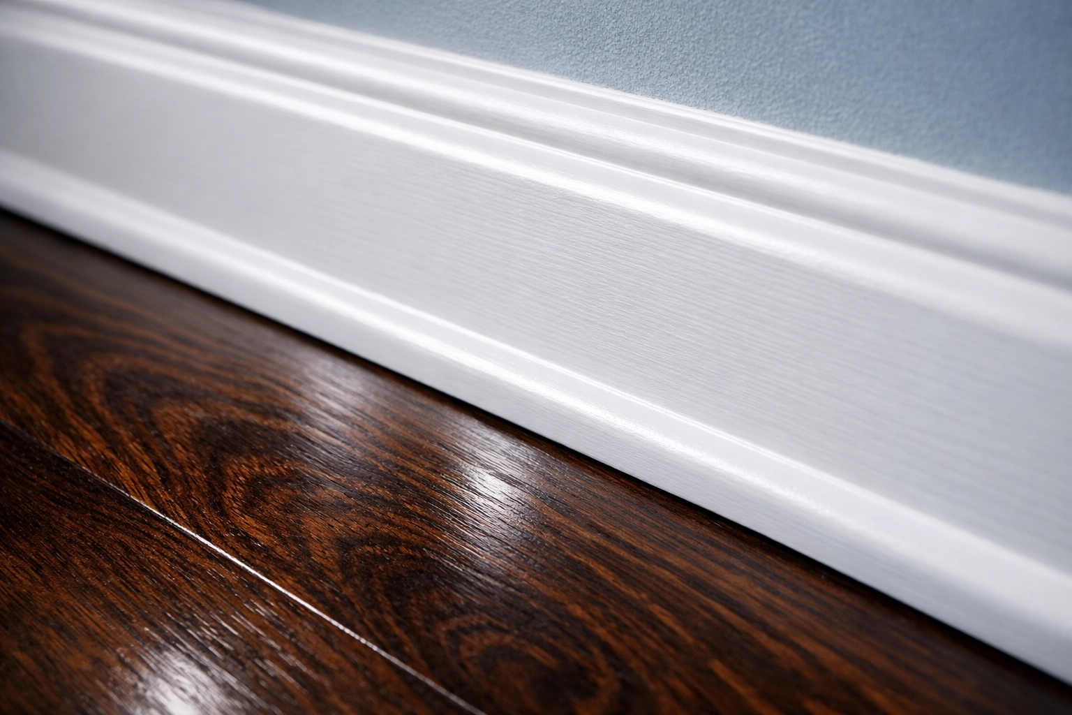 Sparkling clean white baseboard and polished hardwood floor after post-construction cleaning in Newton MA.