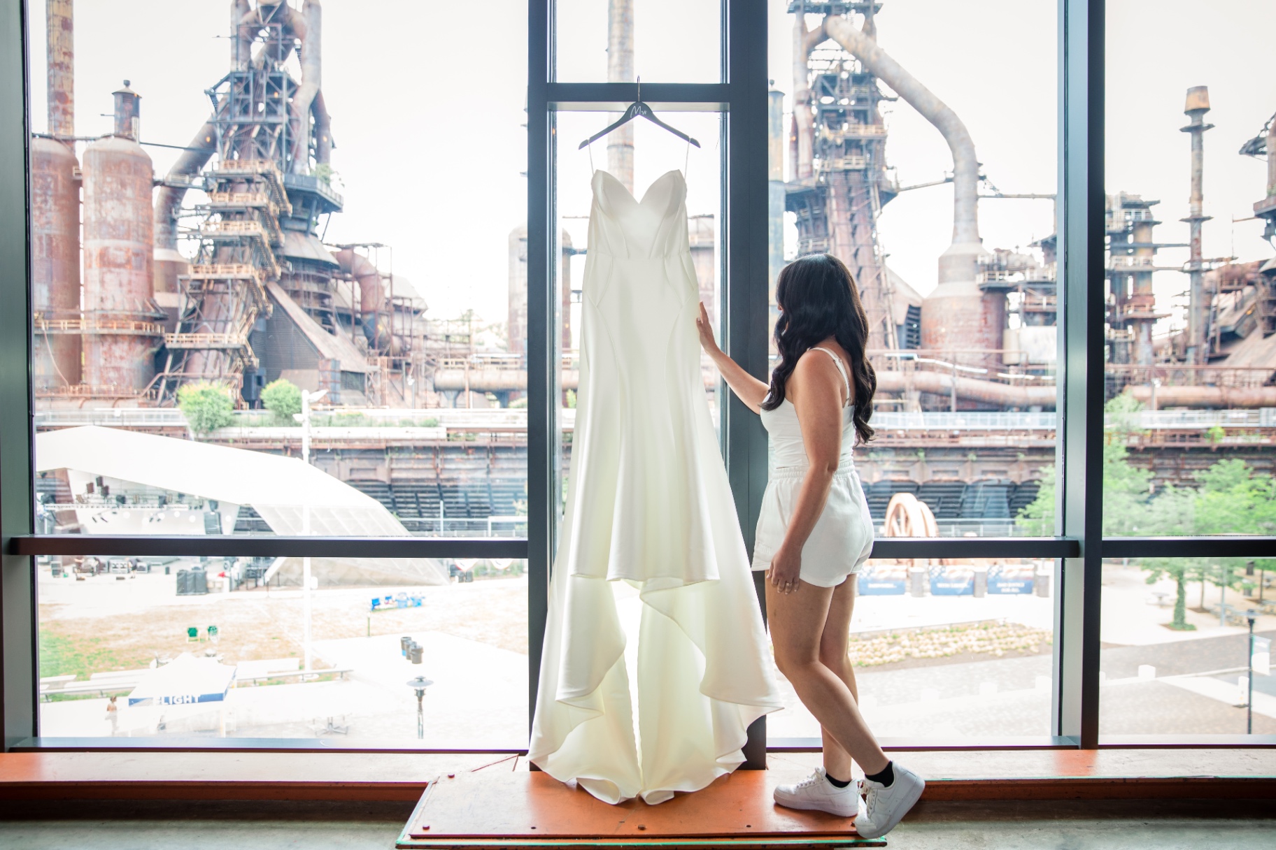 Getting ready at Arts Quest Steel Stacks—Laura with her dress and that bold industrial backdrop