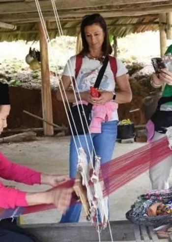 A group of women observe a local artisan weaving on a traditional loom, illustrating the hands-on cultural immersion offered by My Lady Trip.