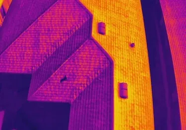High-resolution thermal drone image showing building rooftop heat variation for maintenance planning.