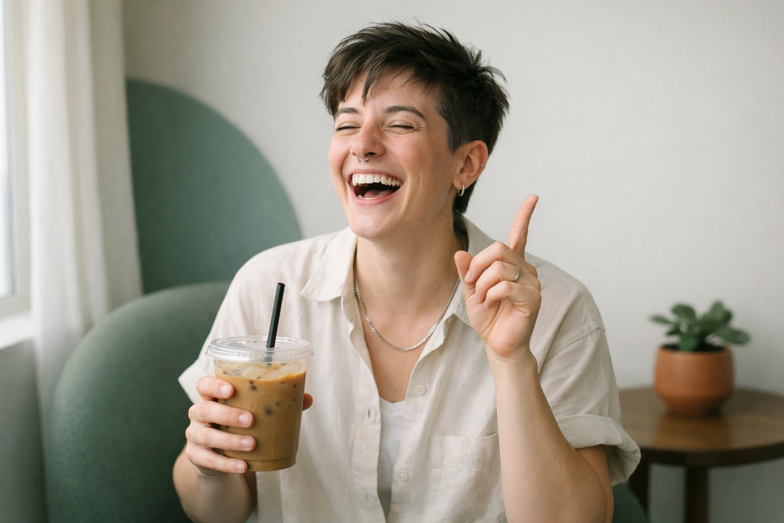Person laughing joyfully while holding a cup of coffee—an “aha!” moment of gender euphoria