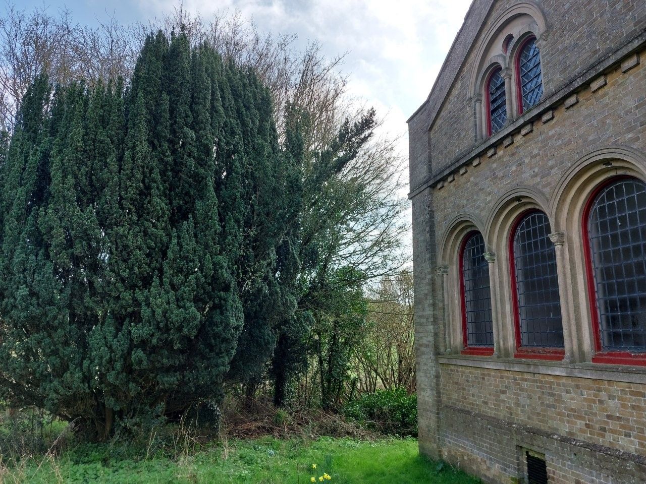 View of the brick-built North Transept of Wareside Church seen from a path in the churchyard.
