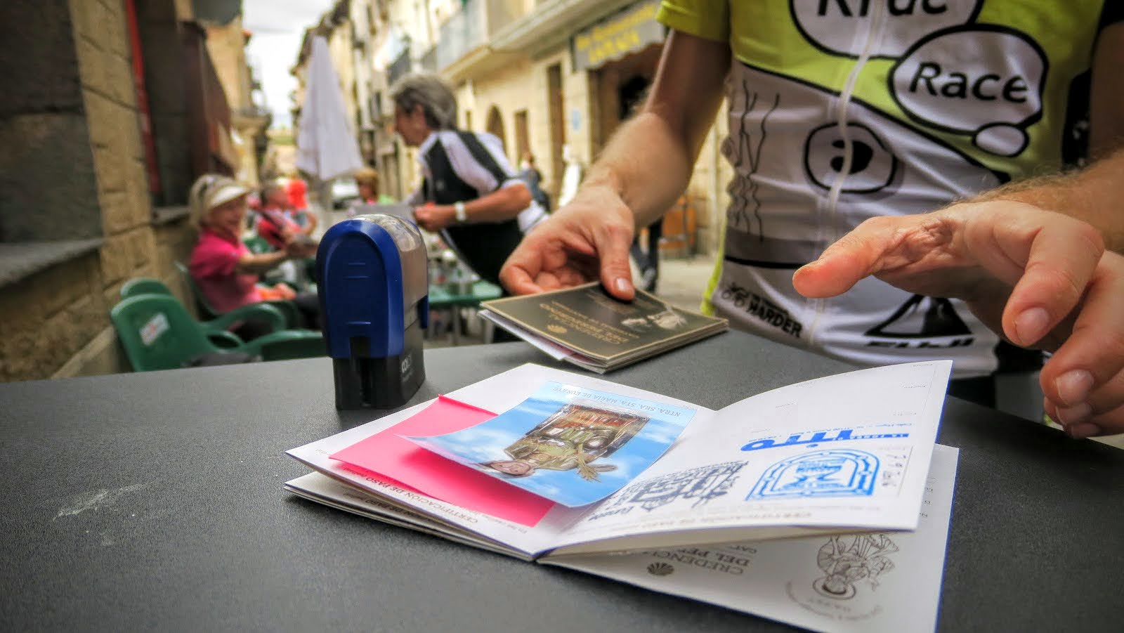 Cyclist Stamping Camino Passport