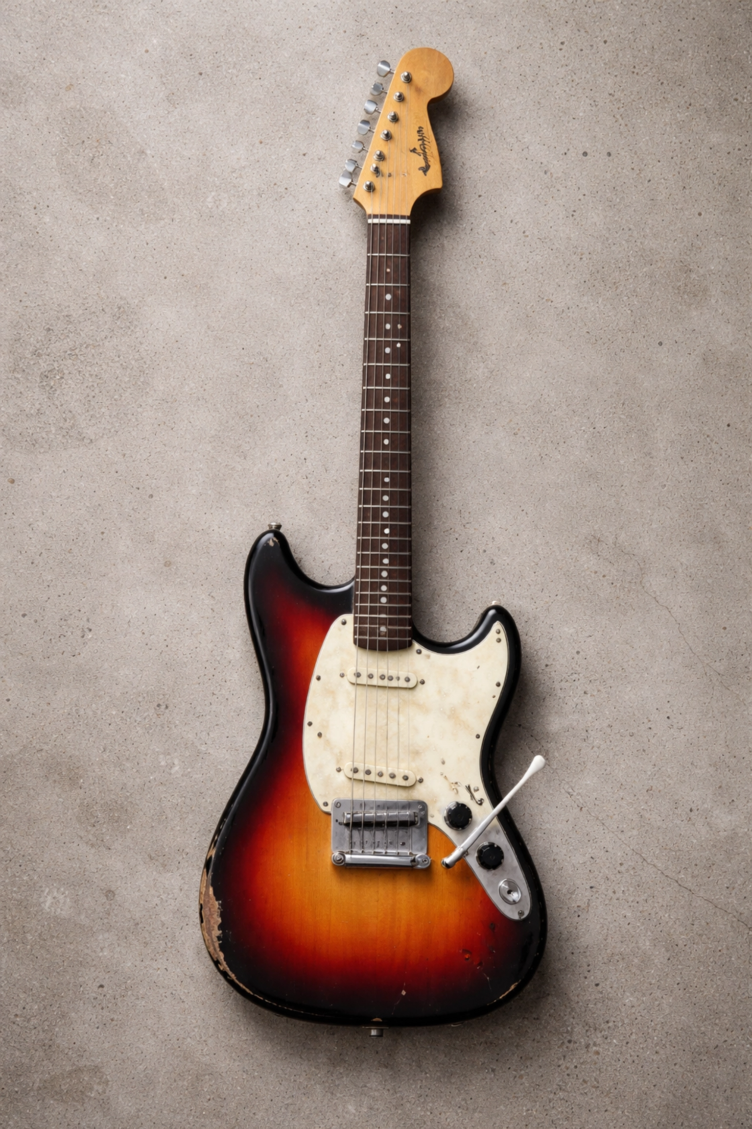 Overhead view of a well-worn vintage Fender Mustang guitar, the instrument behind Nirvana’s Smells Like Teen Spirit
