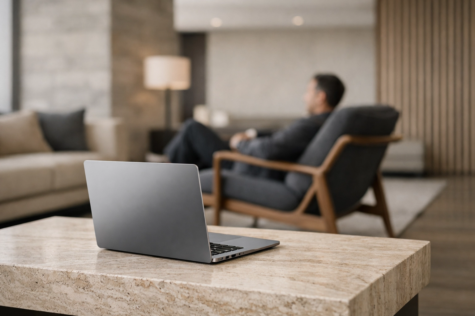 A laptop in a boutique hotel lounge showing a seamless hospitality management workflow.