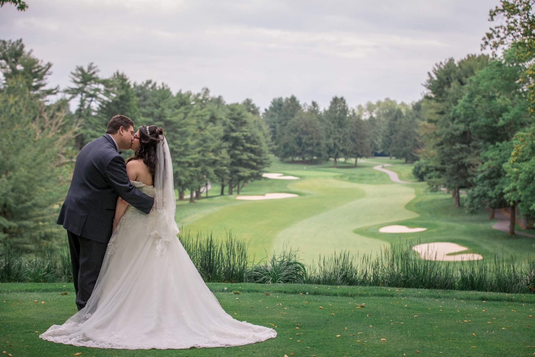 Bride and groom sharing a kiss on the golf course