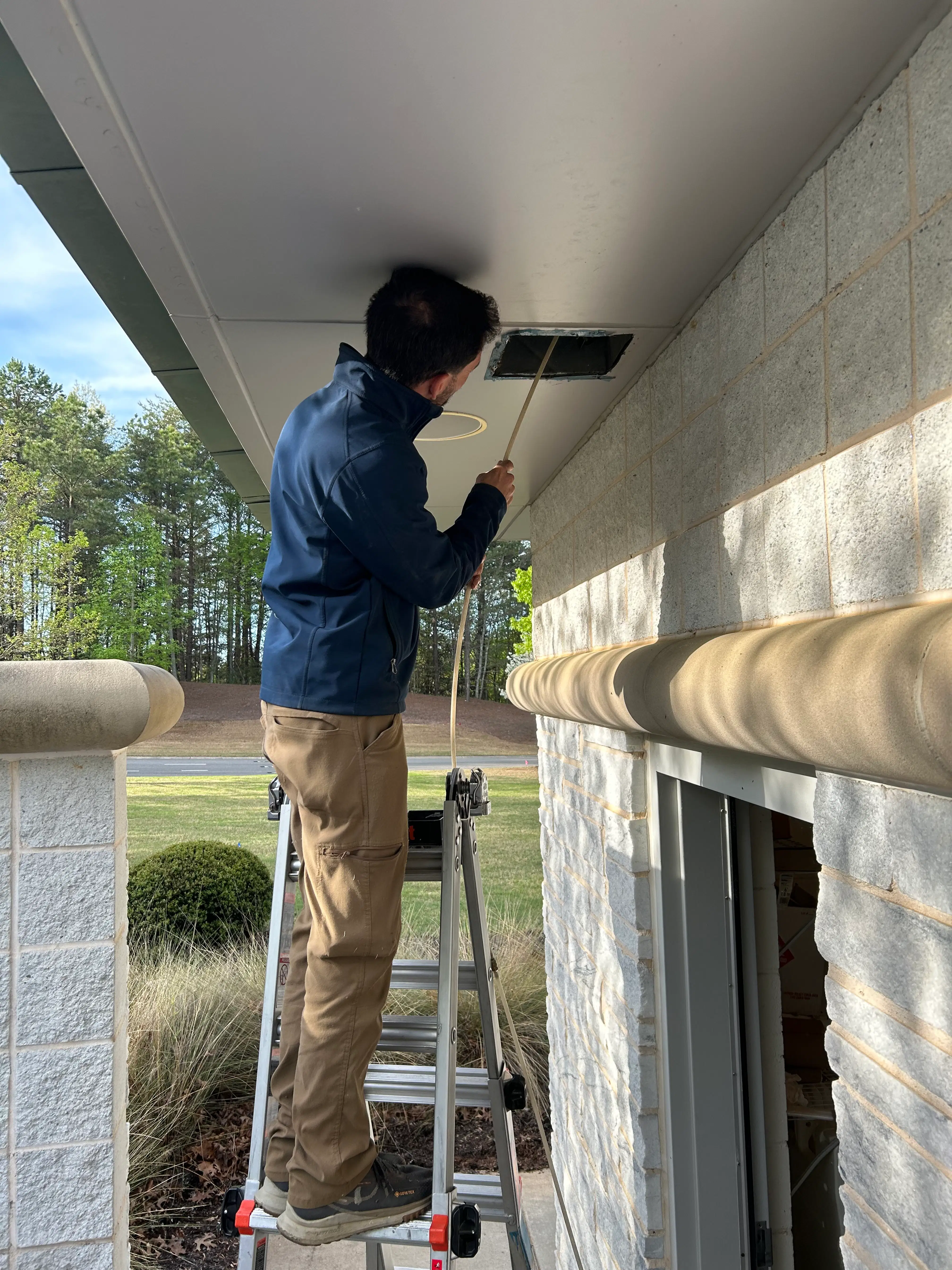 Technician cleaning air duct