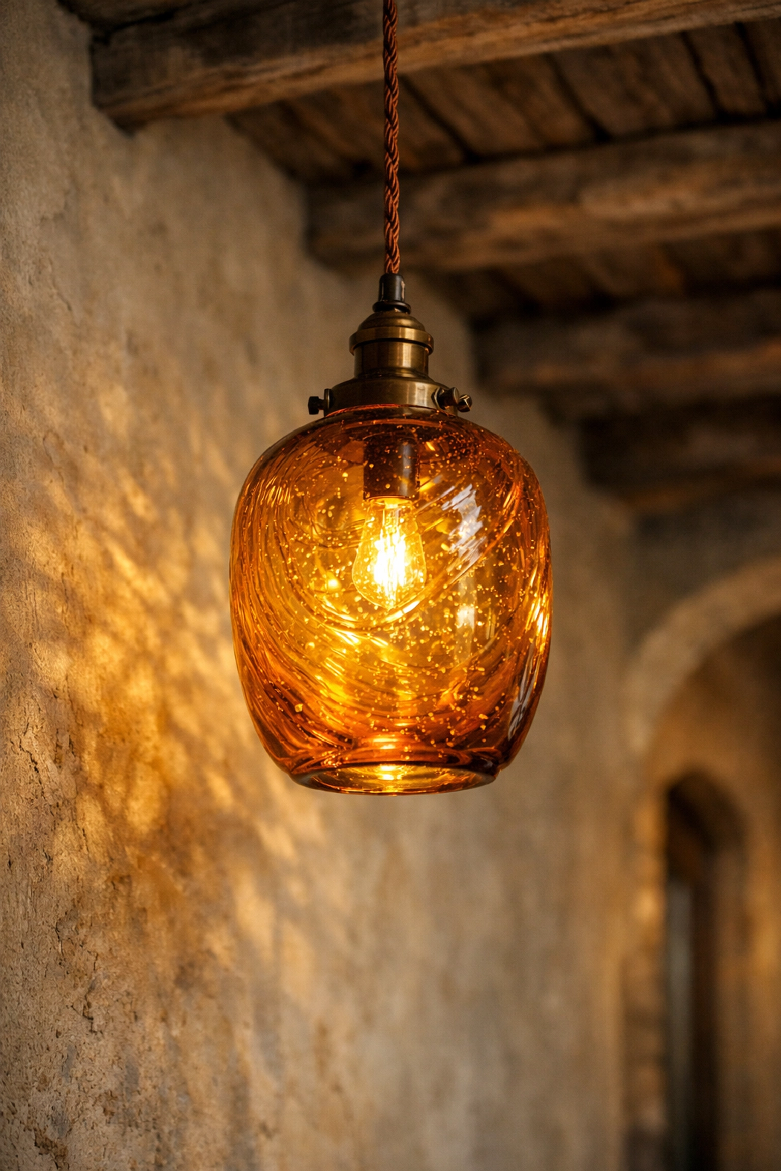 Hand-blown amber glass pendant light adding a warm glow to handcrafted home interior lighting.