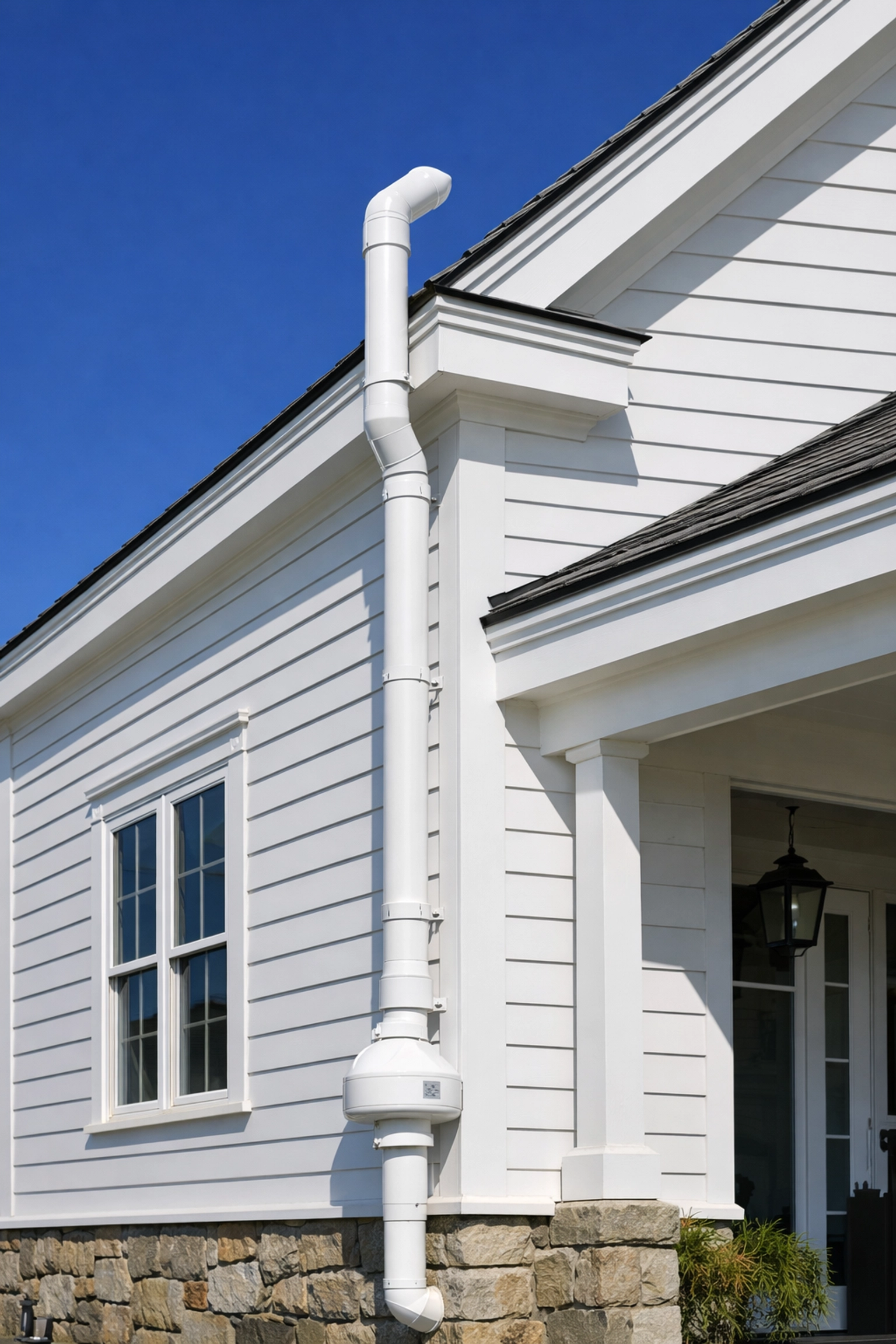 Exterior of a Vermont home featuring a professionally installed radon mitigation system vent pipe for clean air.
