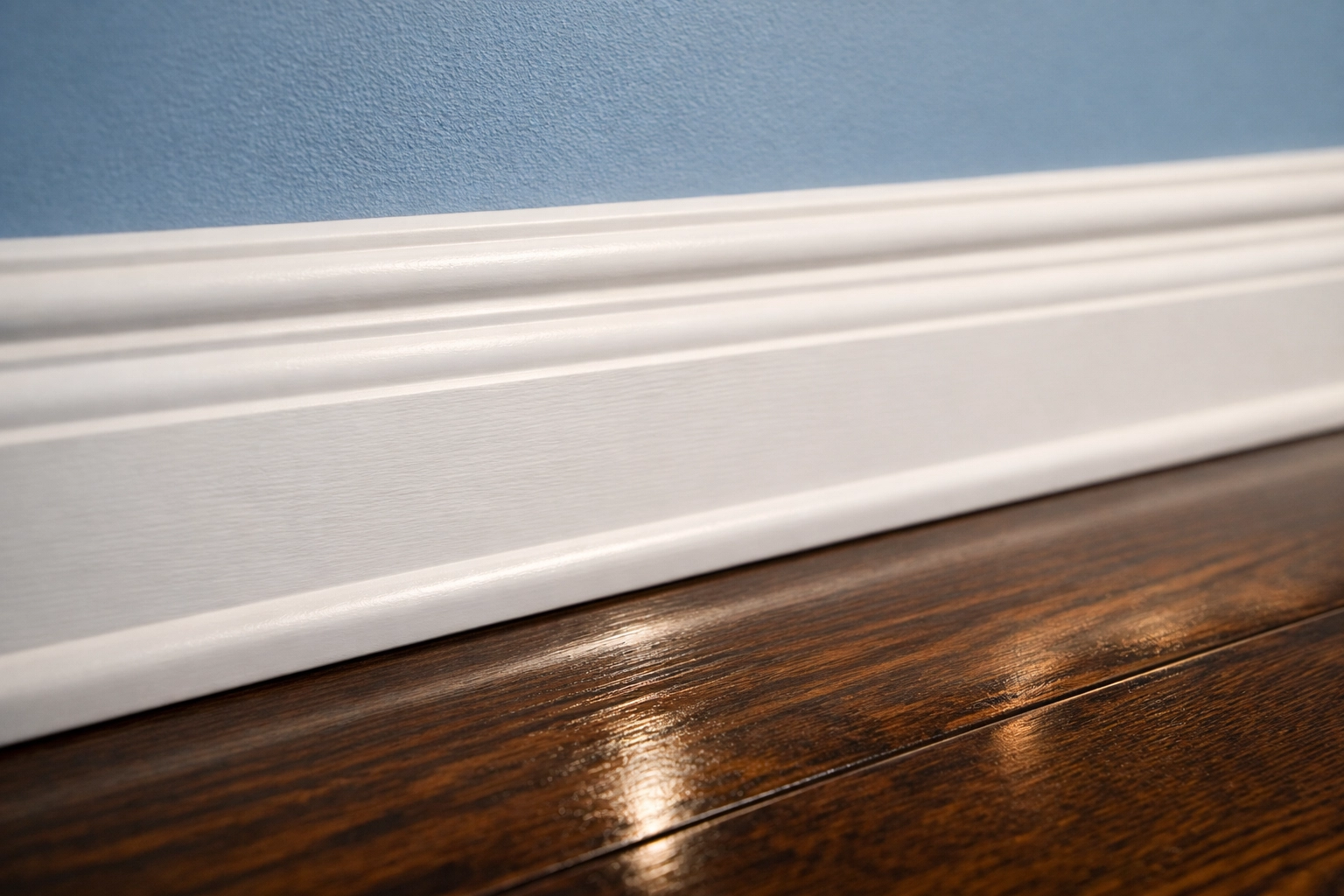 Detail of clean baseboards and polished hardwood floors in a Groton apartment after move-out cleaning.