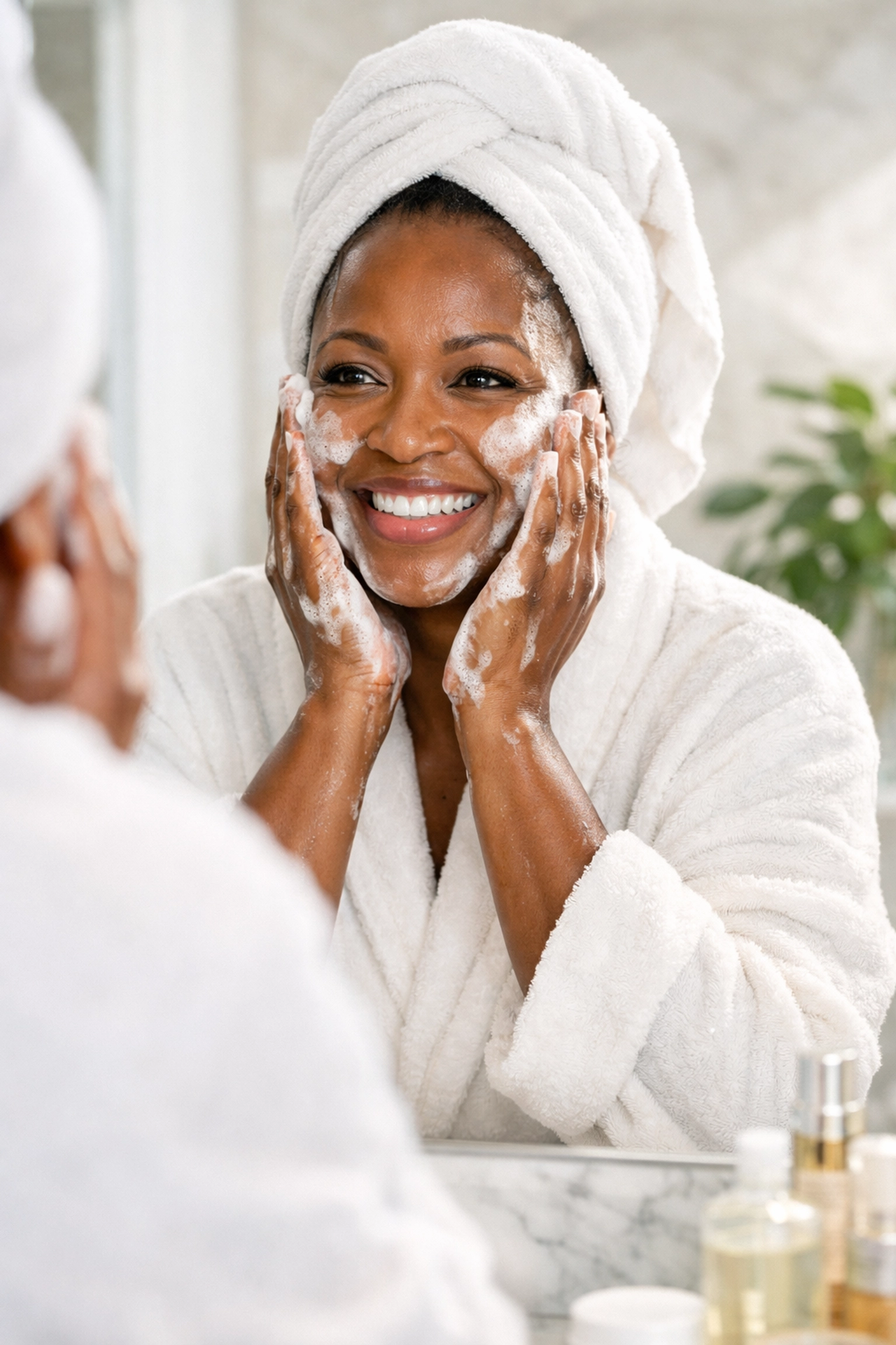 Vibrant Black woman in her 40s enjoying a gentle foaming cleanser during her morning skincare ritual.