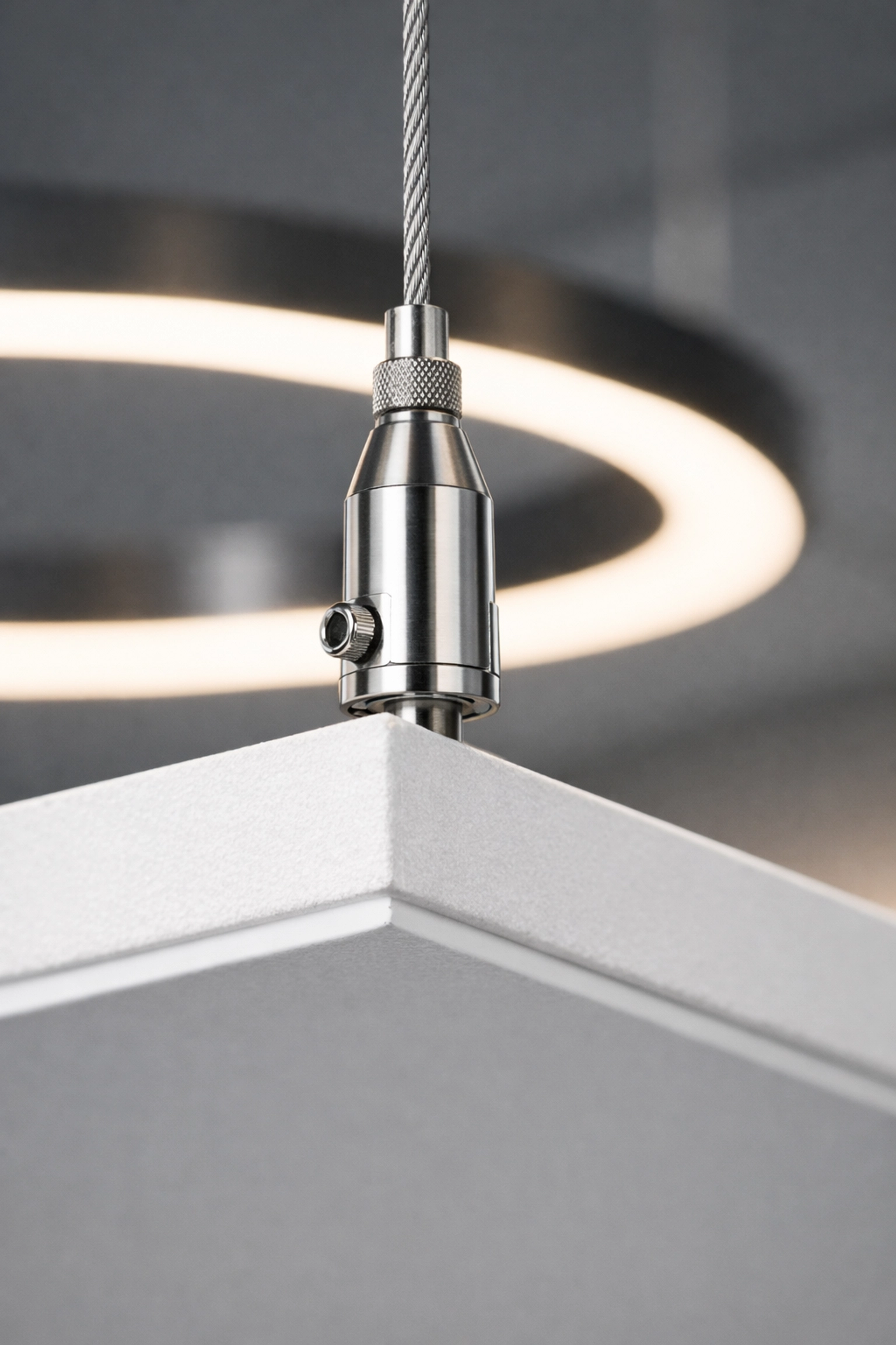 Close-up of precision suspension hardware for mounting an acoustic cloud ceiling panel.