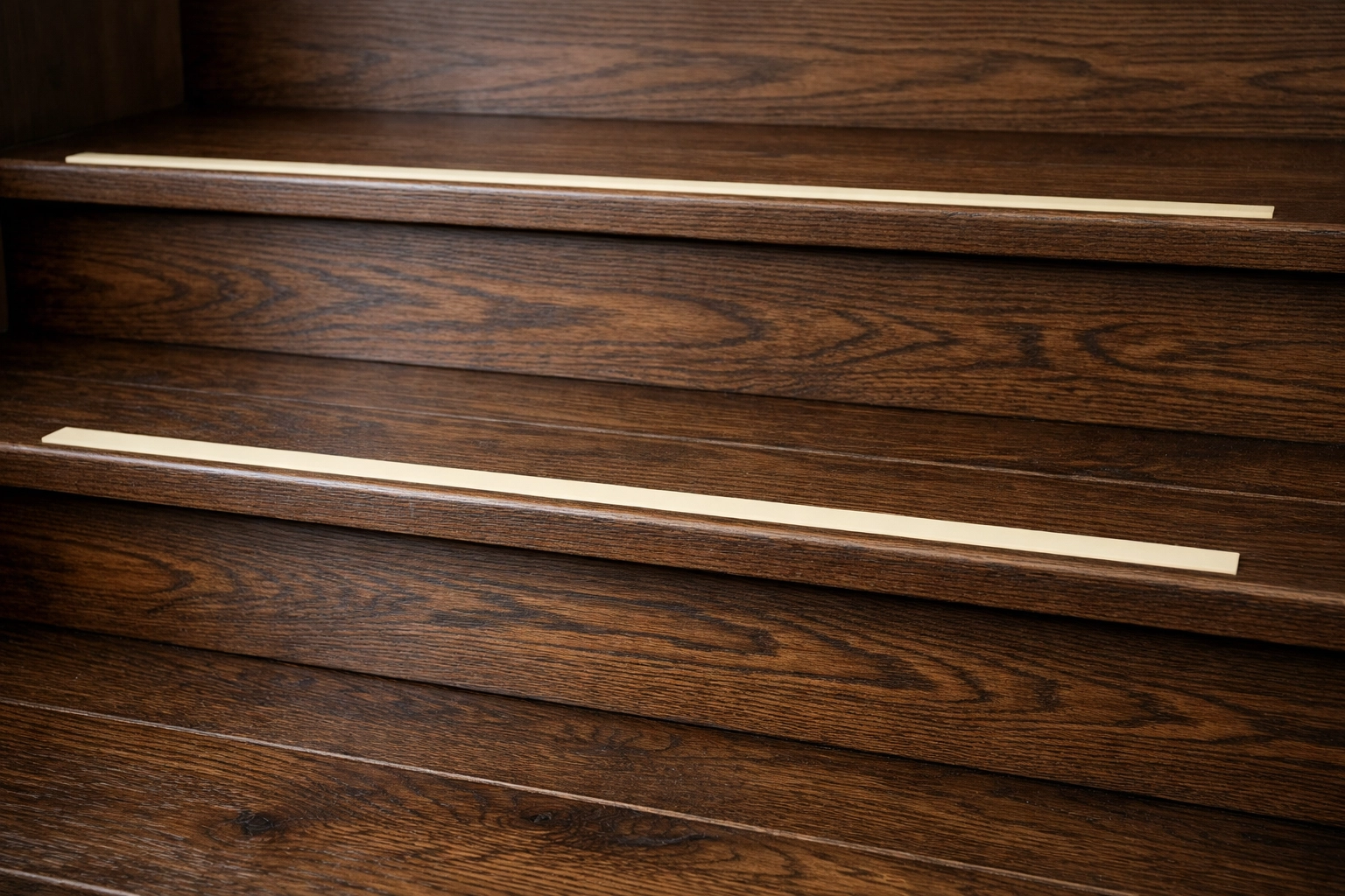 Contrasting safety strips on dark wooden stair edges to help seniors with depth perception.