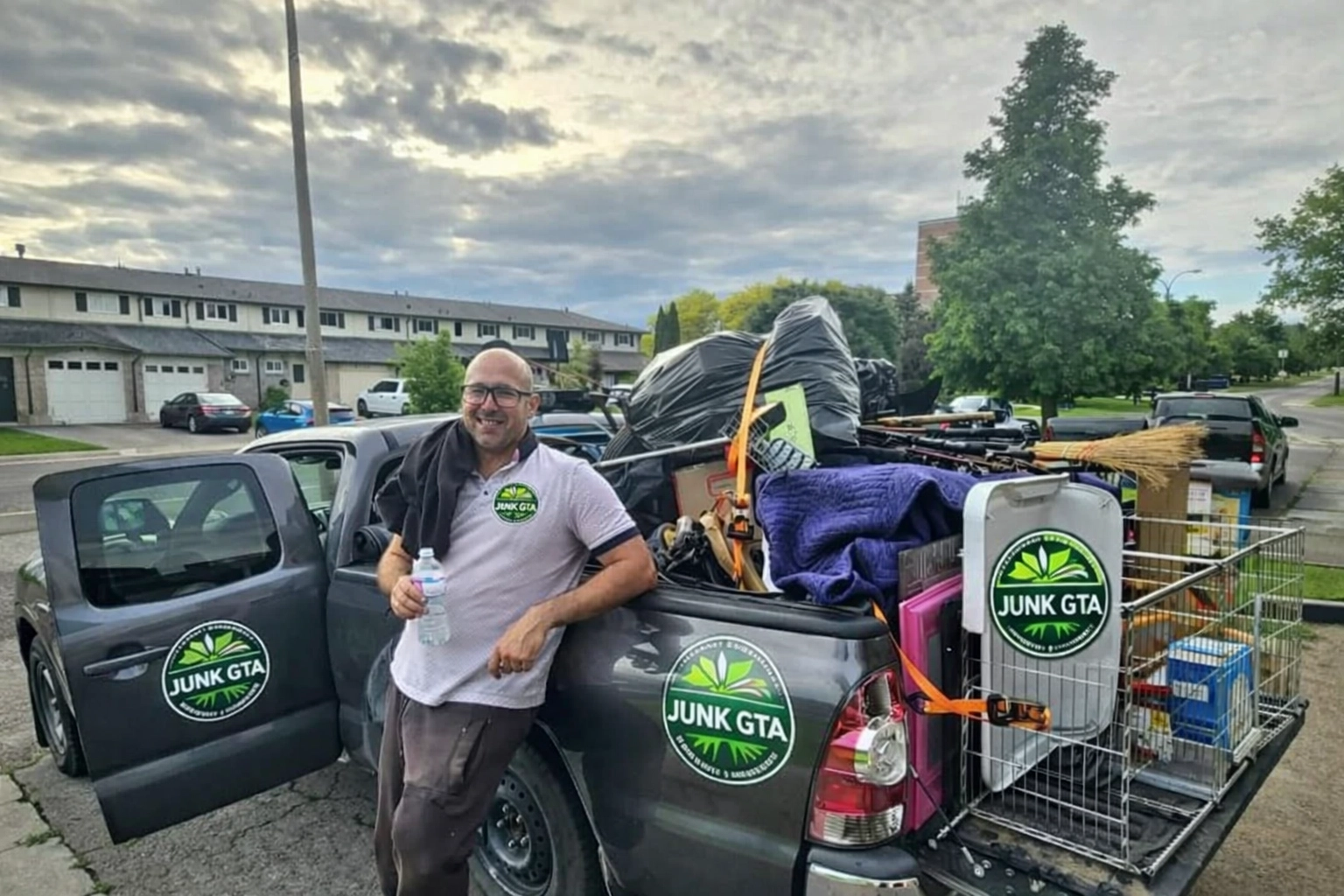 Roman, owner of Junk GTA, standing by his 2014 Toyota Tacoma loaded with junk