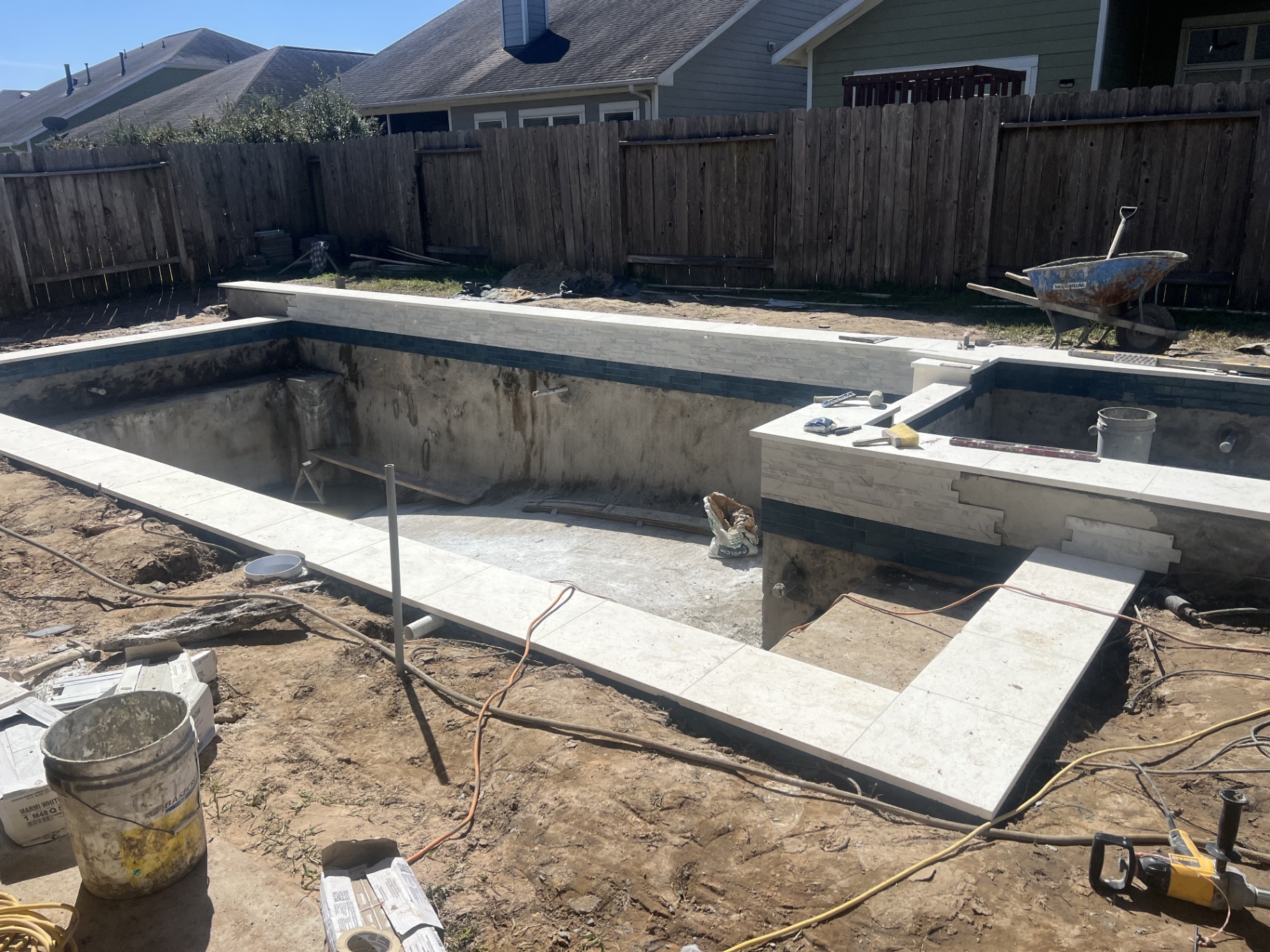 Official pool permits and blueprints on a desk, representing the permit process for building a pool in The Woodlands