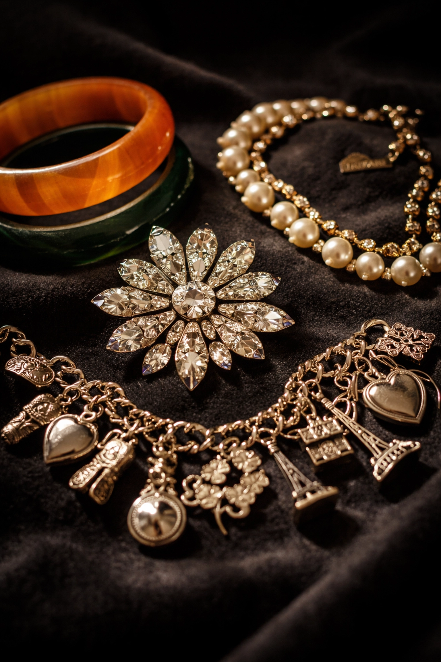Vintage costume jewelry including rhinestone brooches, Bakelite bangles, and charm bracelets with resale value