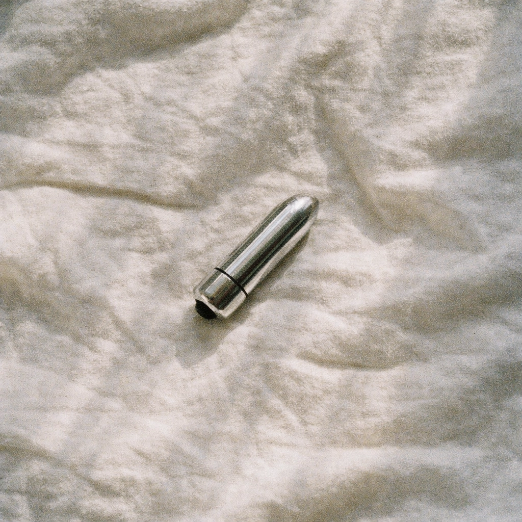 Simple bullet vibrator on white bed sheets - ideal first sex toy for beginners