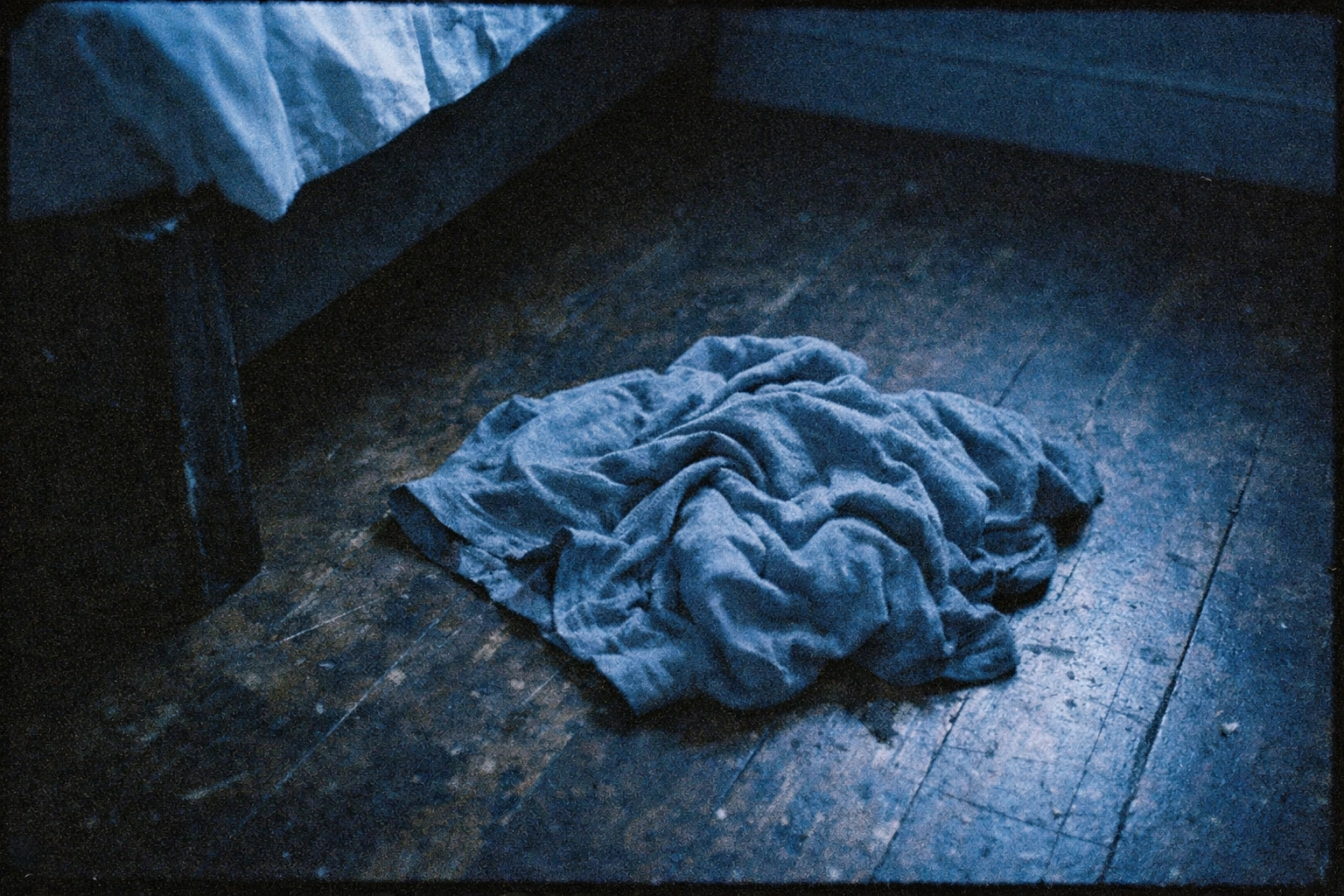 Discarded t-shirt on a wooden floor, representing the lingering sexual arousal scent.