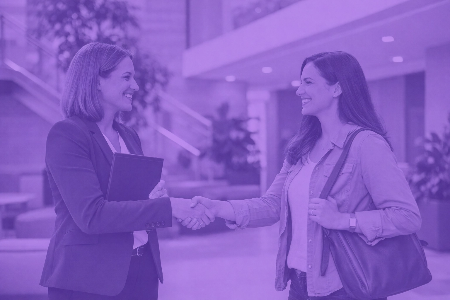 Property manager and tenant shaking hands in a lobby, showing human connection enabled by AI leasing automation.