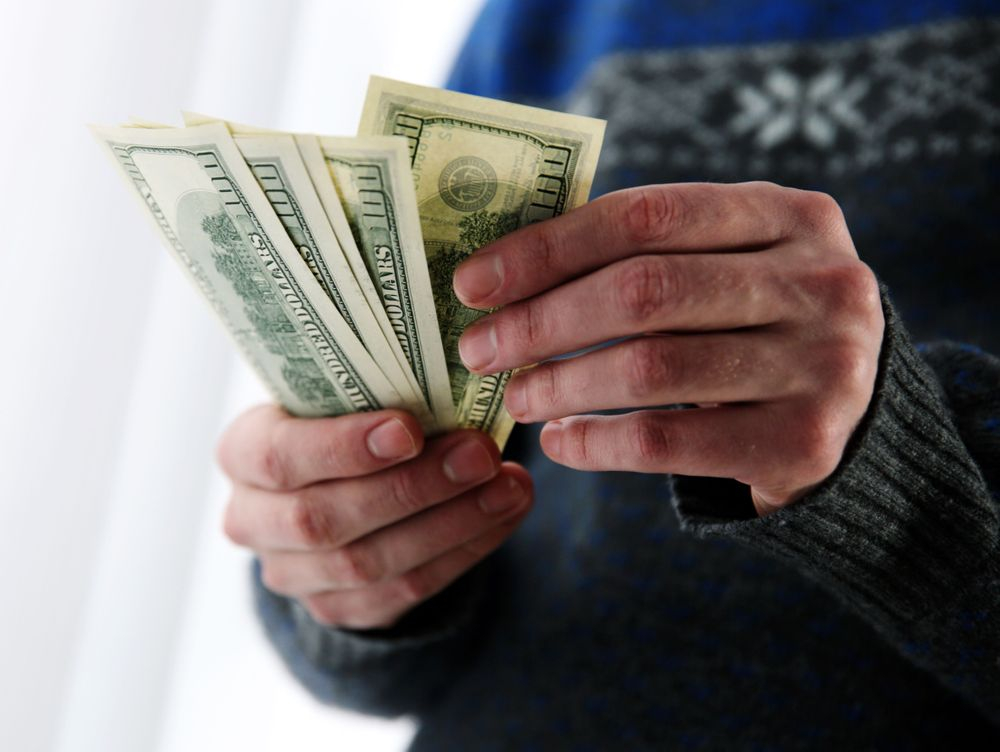 Person Counting $100 Bills for Tax Savings