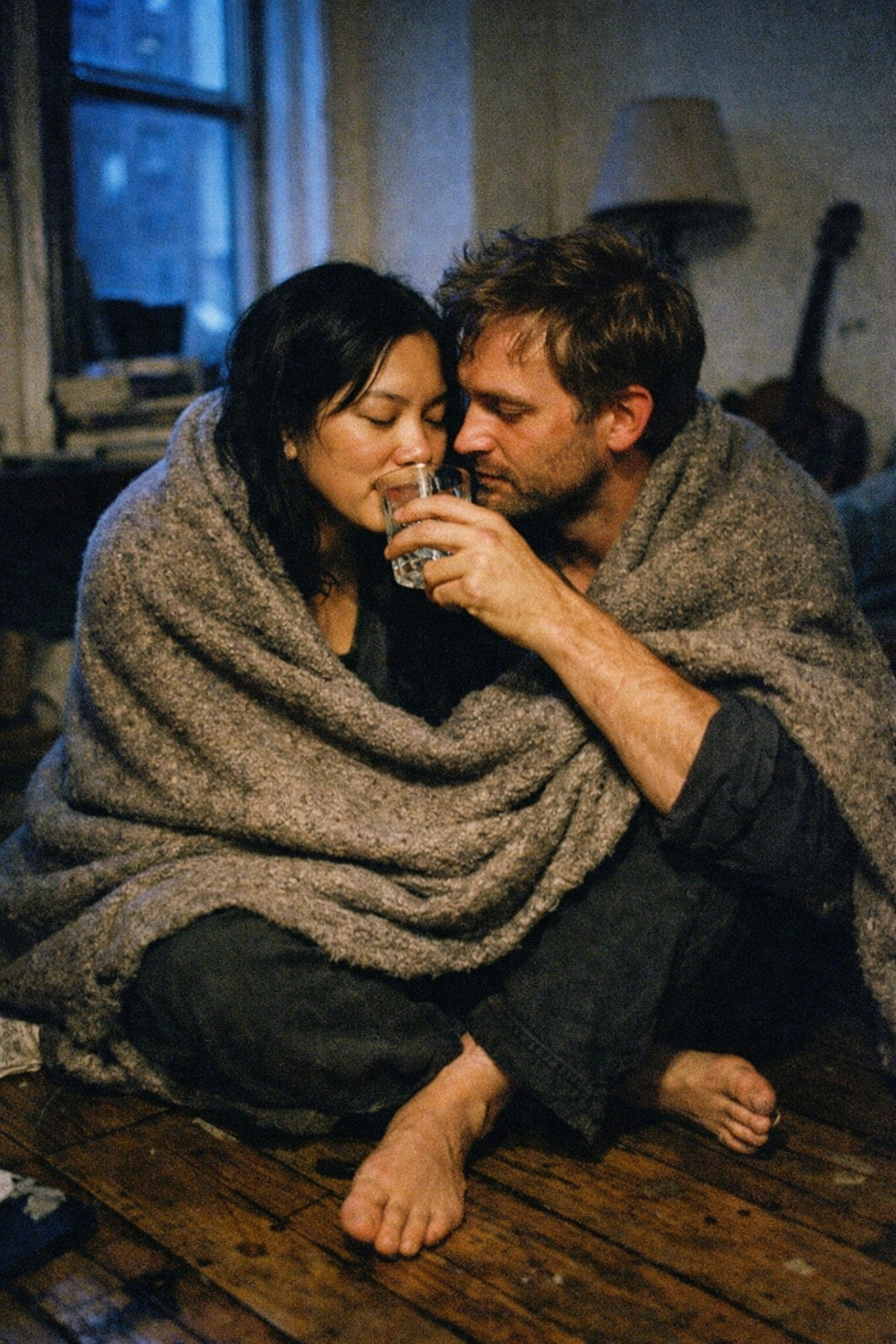 A couple practices BDSM aftercare, sharing water and a blanket to manage sub drop.