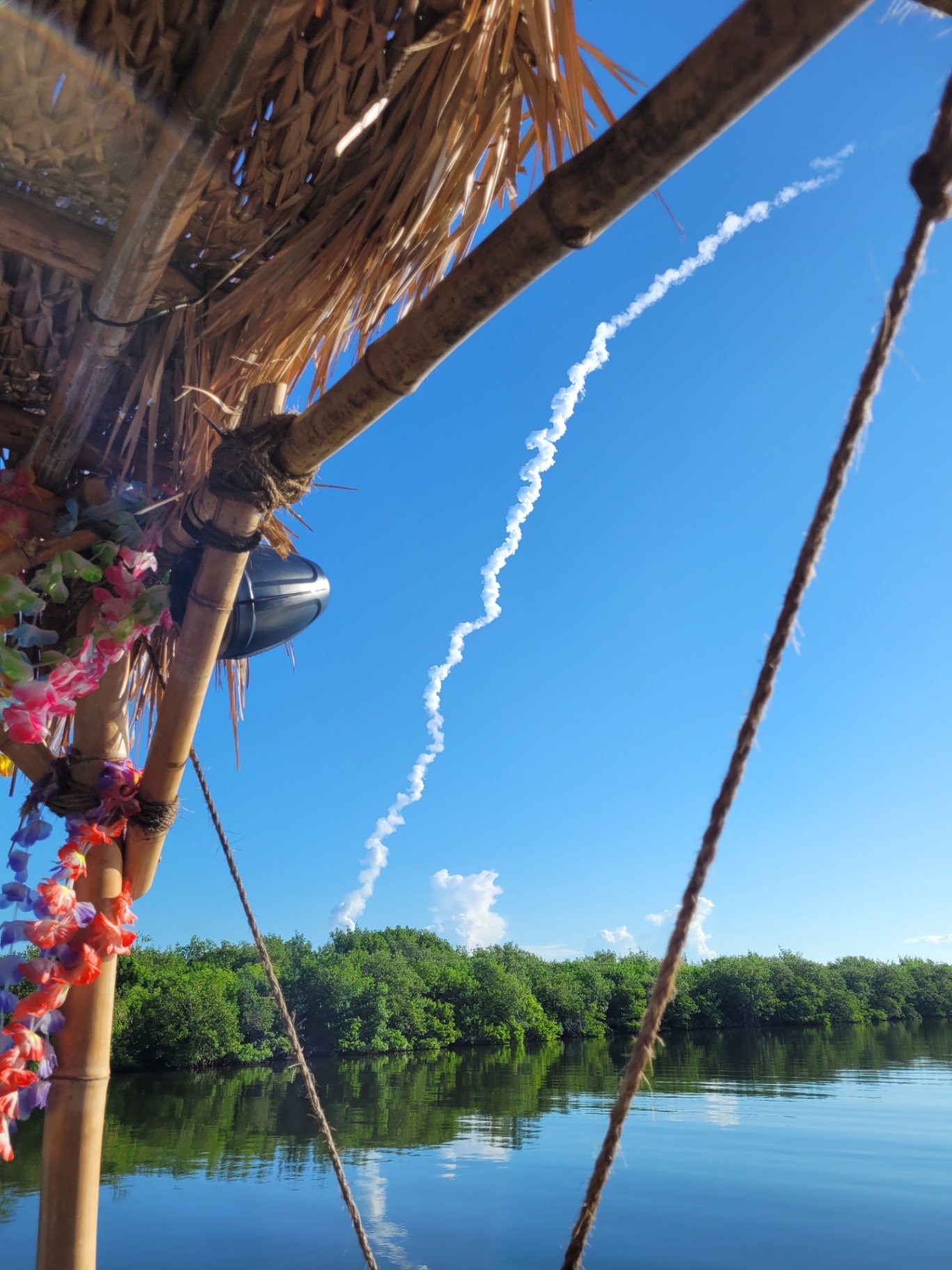 View from the Lei'd Back tiki boat featuring tropical decorations and a rocket launch streaking into the sky.