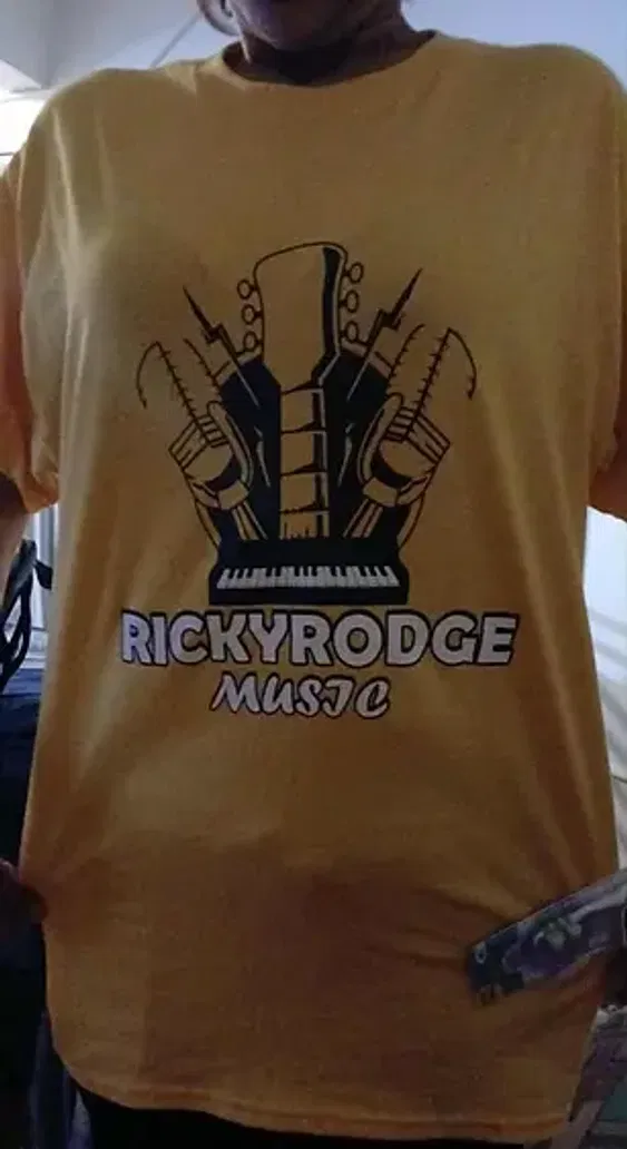 A yellow custom screen printed T-shirt featuring a music logo with bold black artwork and white lettering.