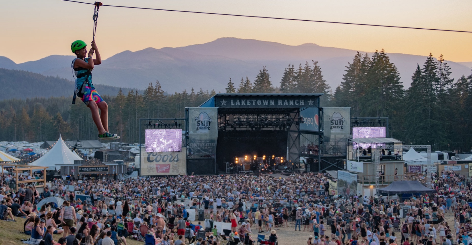 Outdoor Music Festival at Laketown Ranch A vibrant outdoor music festival held at Laketown Ranch featuring a large crowd, live stage performances, and a scenic mountain backdrop.